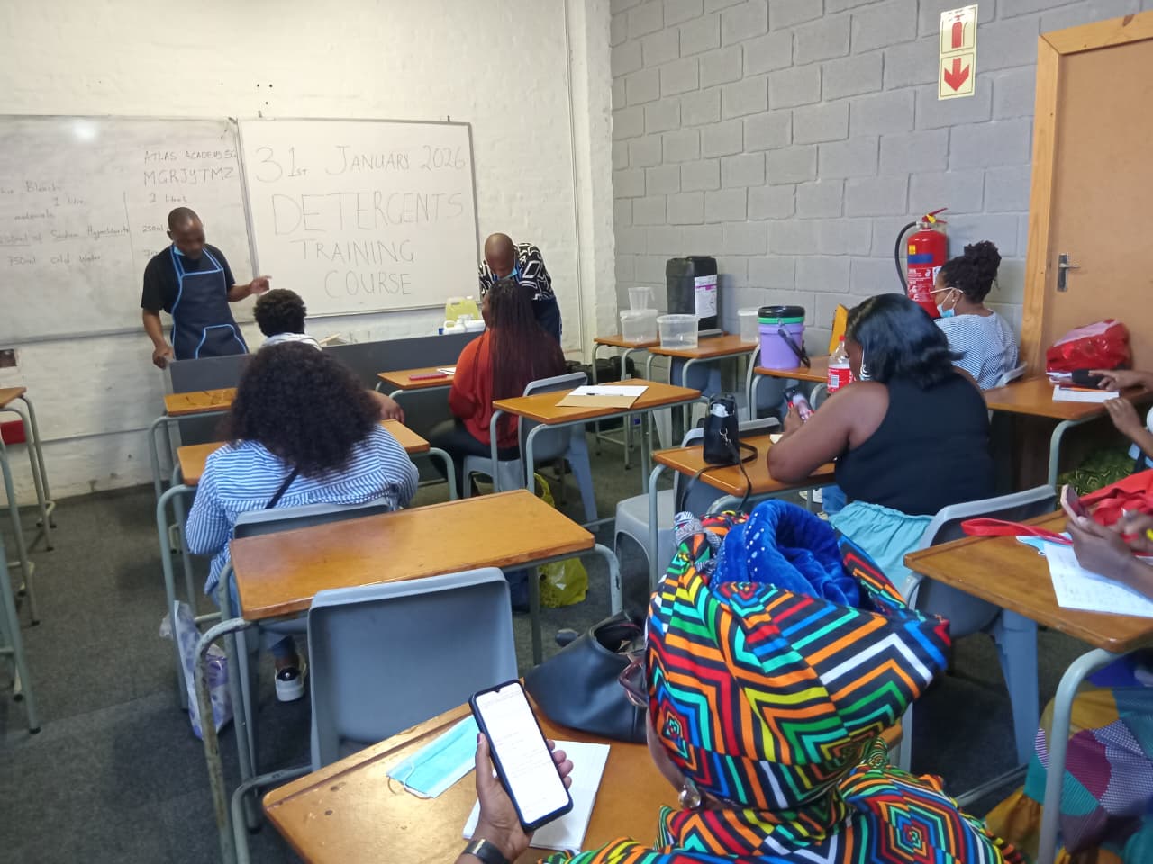 Instructor demonstrates in a classroom during a detergents training course