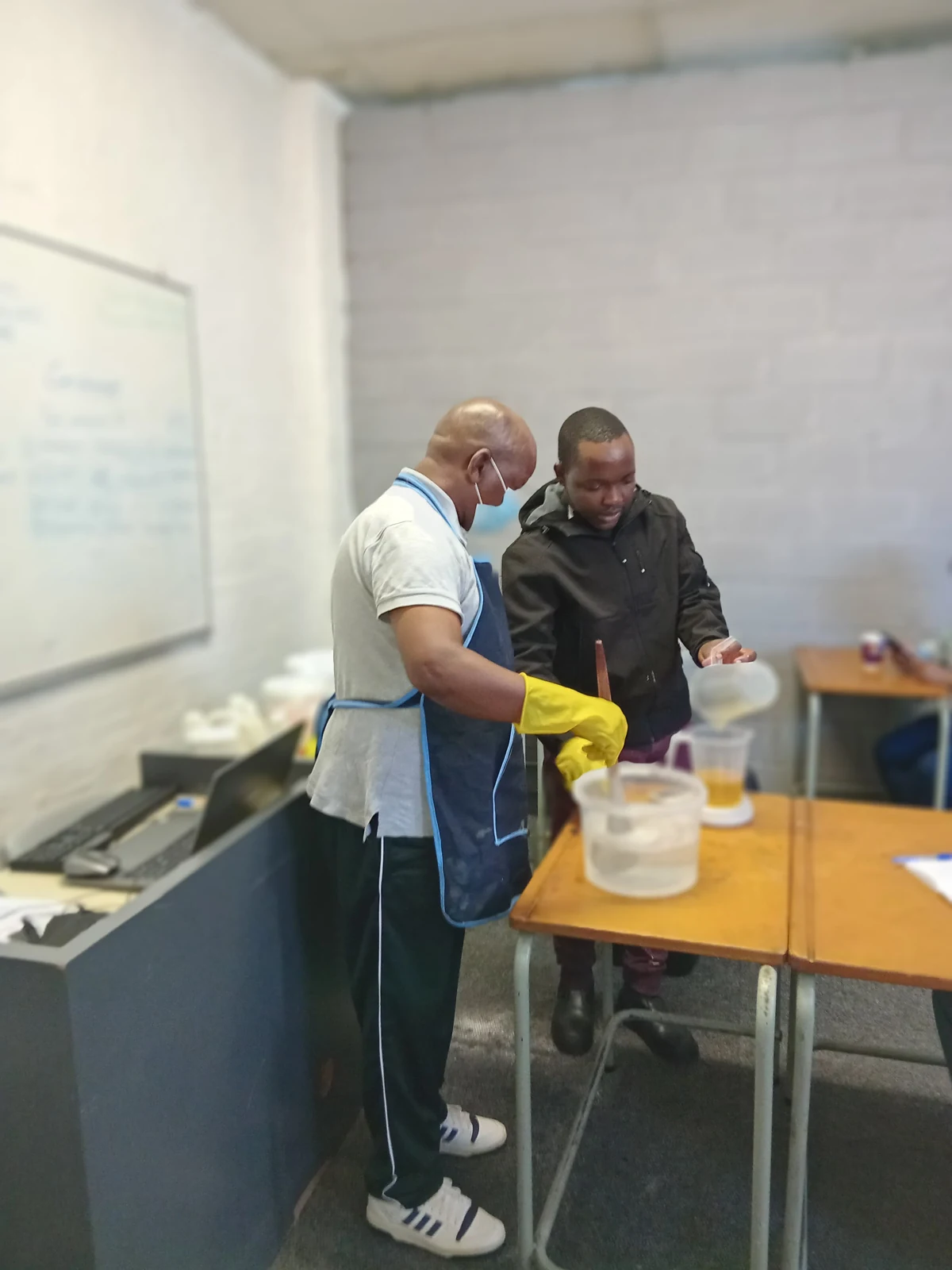Two people mixing detergent during a practical training session