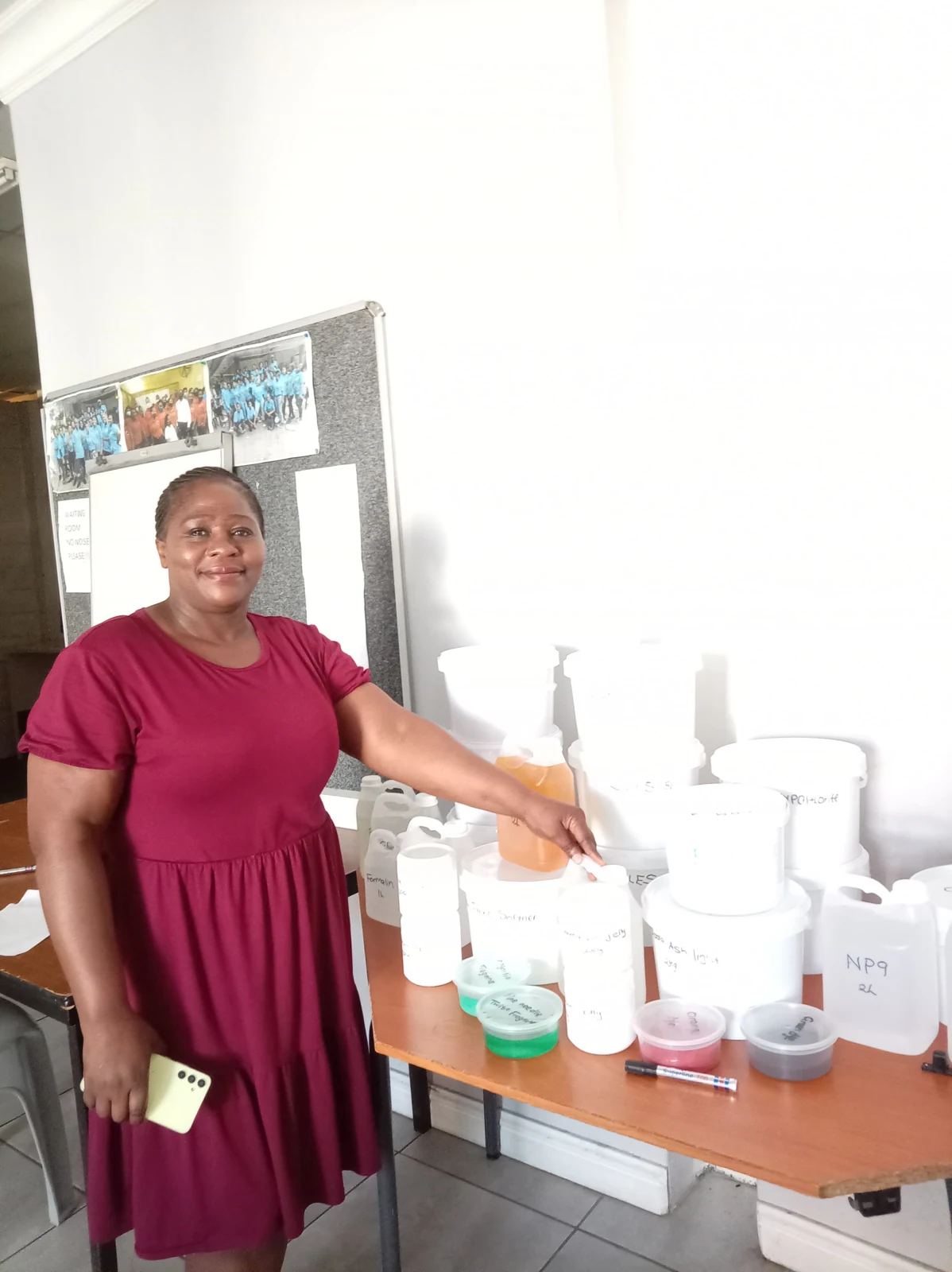 A woman beside containers of detergent-making materials